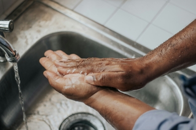 A person washing their hands in a sink